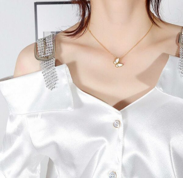 Women's delicate butterfly wing necklace with classic pearl chains made of stainless steel and plated in gold.